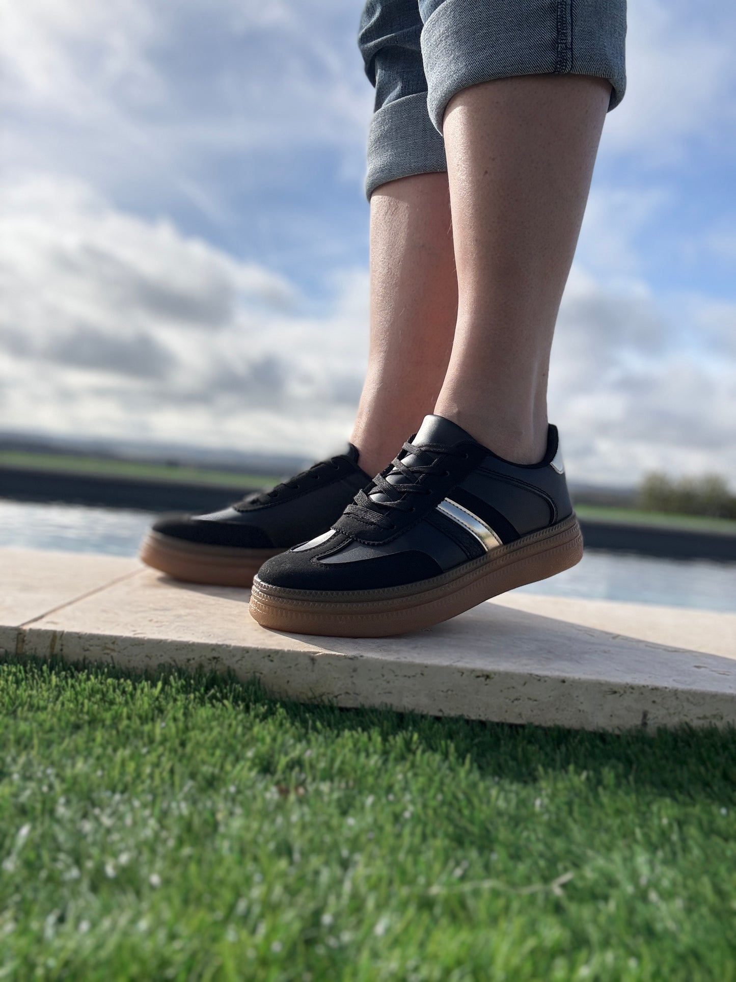 Chaussures baskets basses style sneakers campus noir avec une bande dorée