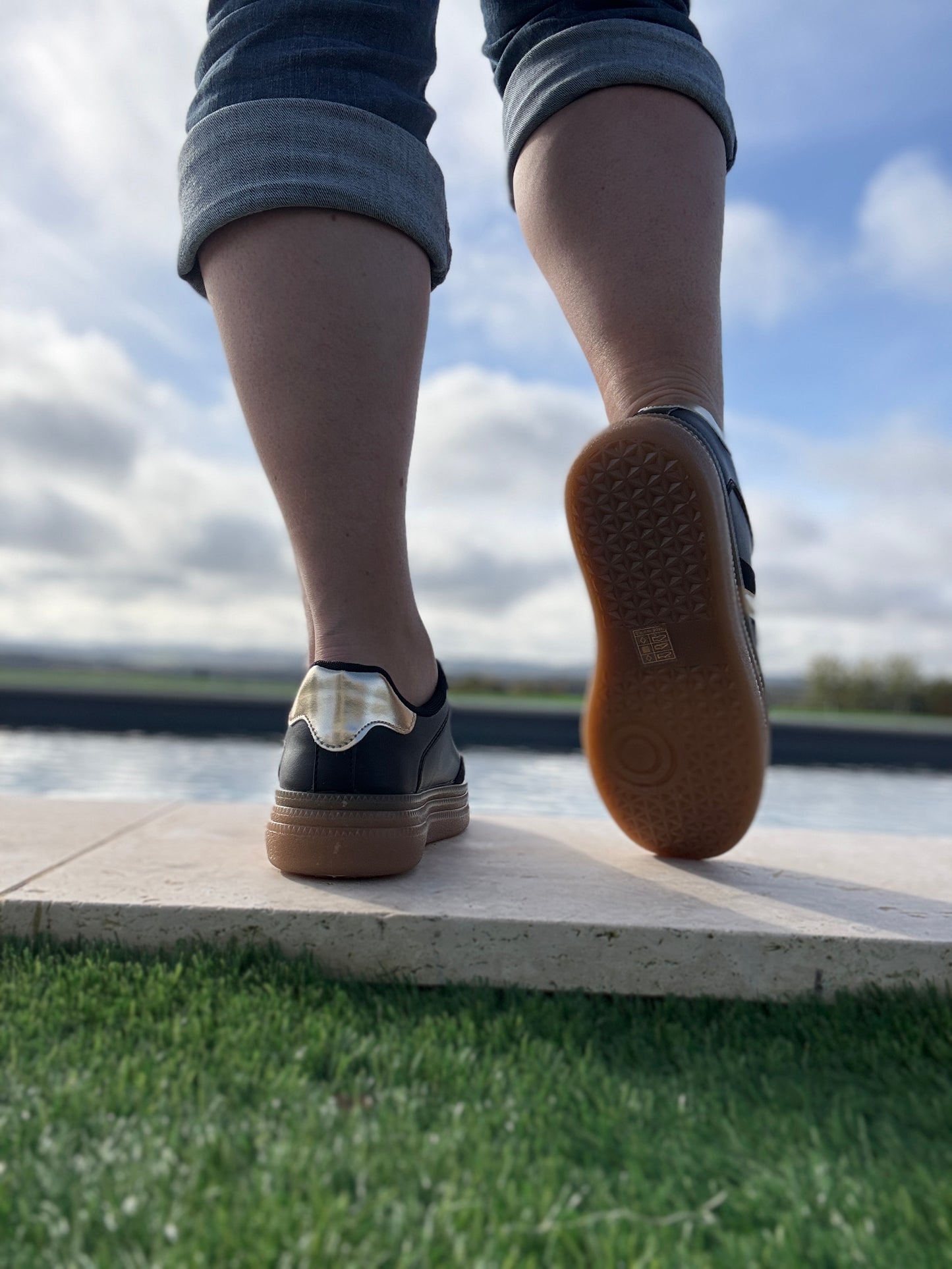 Chaussures baskets basses style sneakers campus noir avec une bande dorée