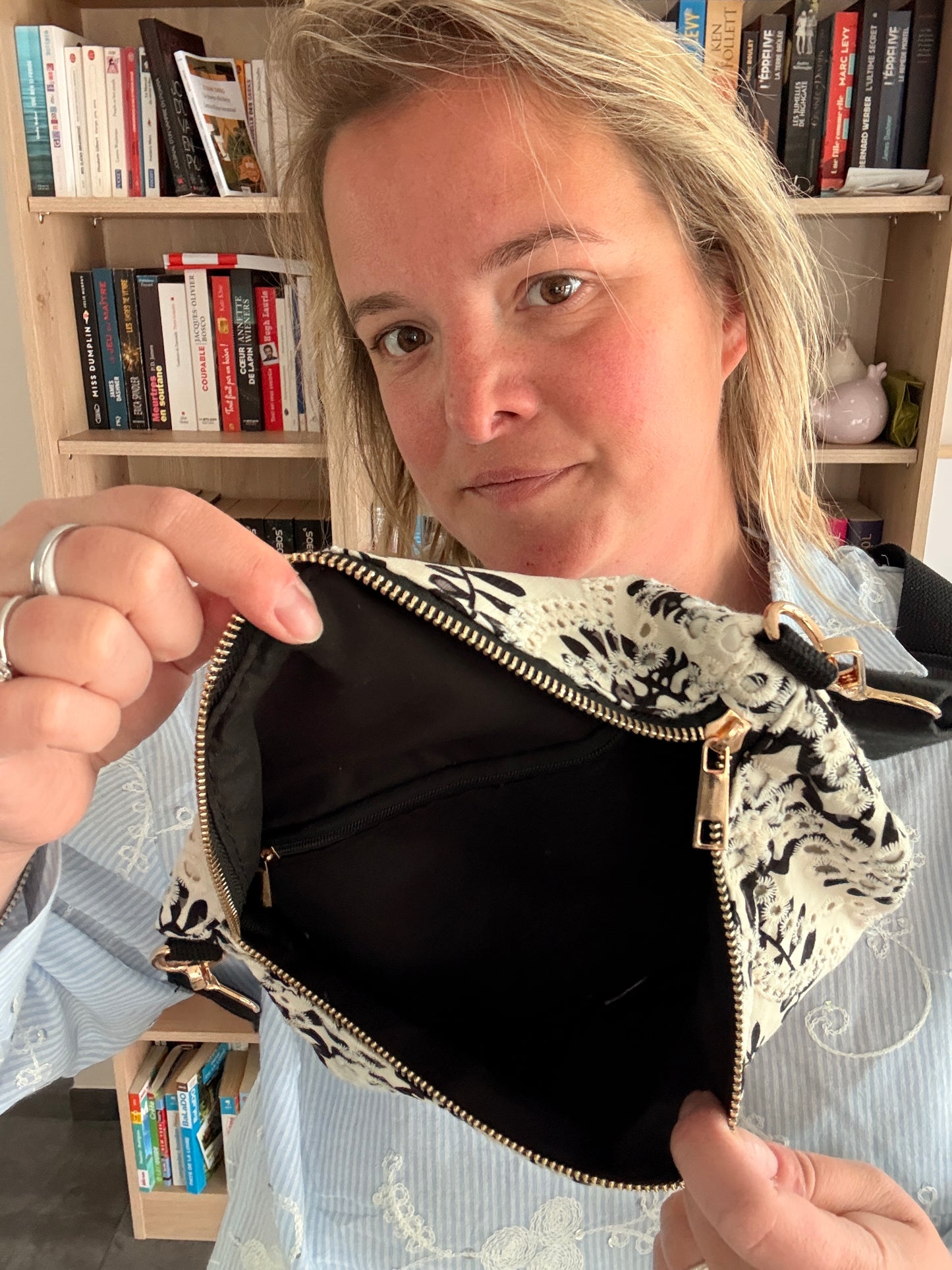 Sac banane femme floral noir et blanc léger et pratique, montrant l’intérieur noir avec doublure beige et fermeture éclair dorée.