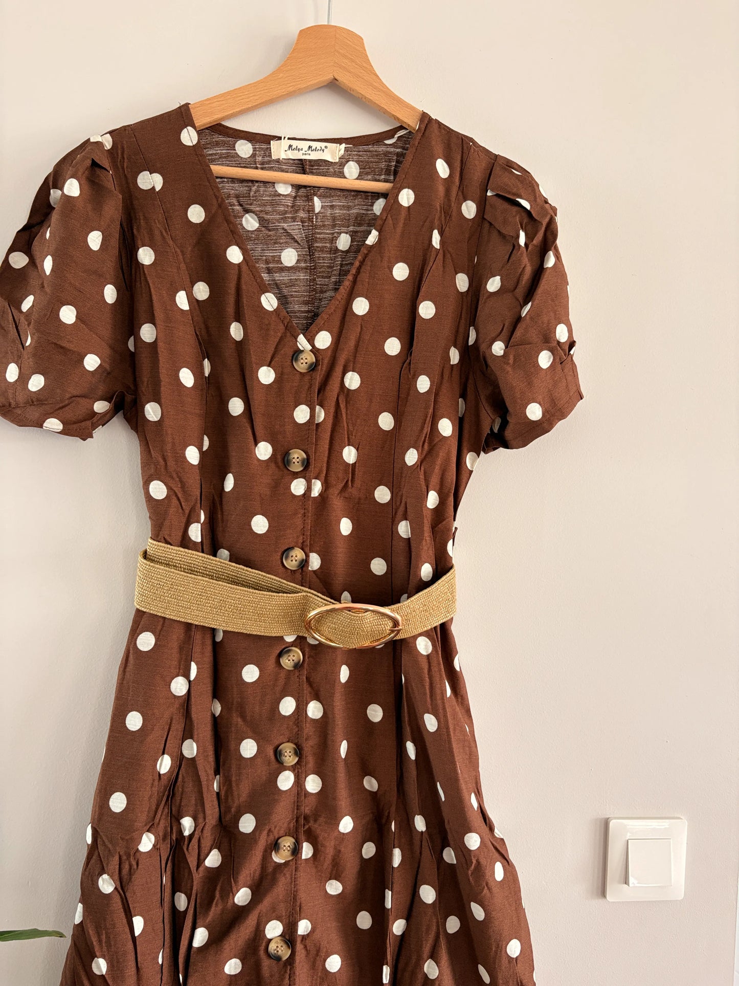 Robe midi à pois beige sur fond marron avec manches bouffantes et col en V, ceinture paille texture gansée, boutons frontaux. Style vintage.