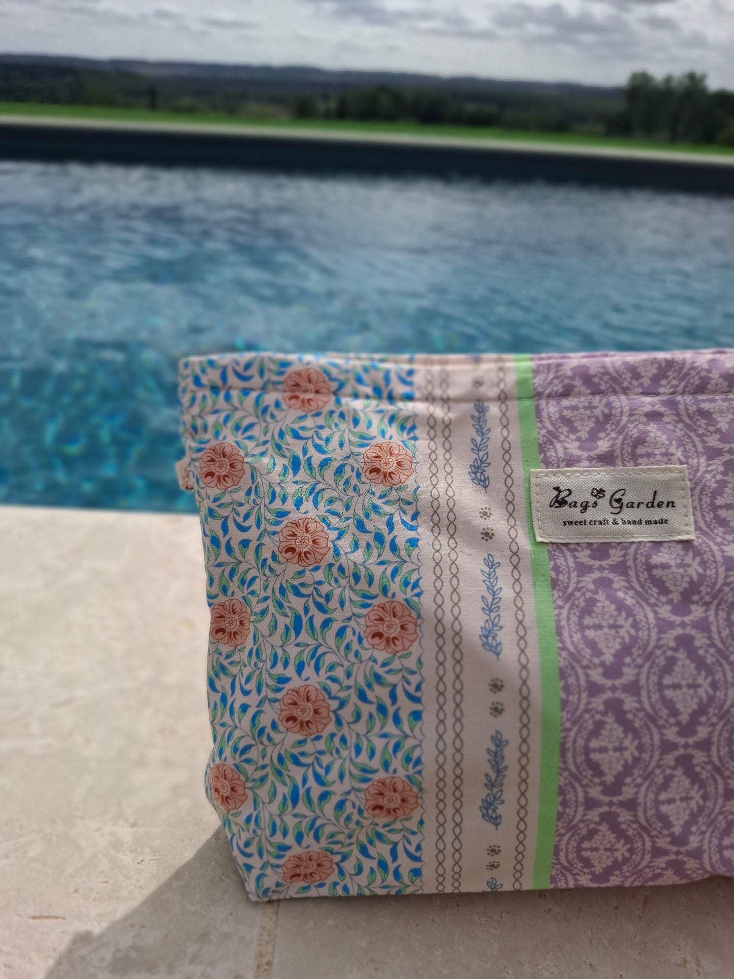 Trousse en tissu imperméabilisé motifs patchwork fleuri avec des motifs géométriques orange rose bleu