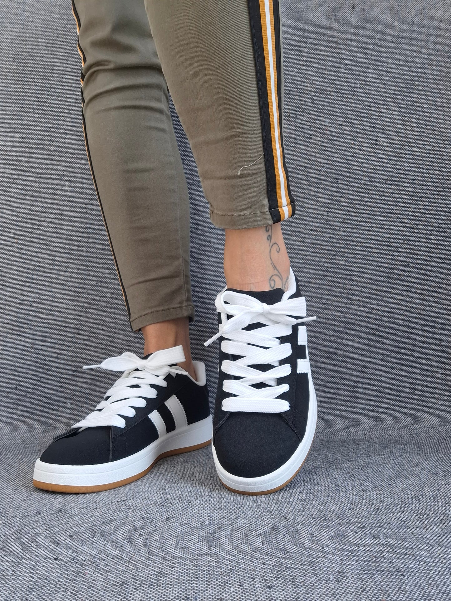Chaussures baskets basses noires à rayures blanches style sneakers campus