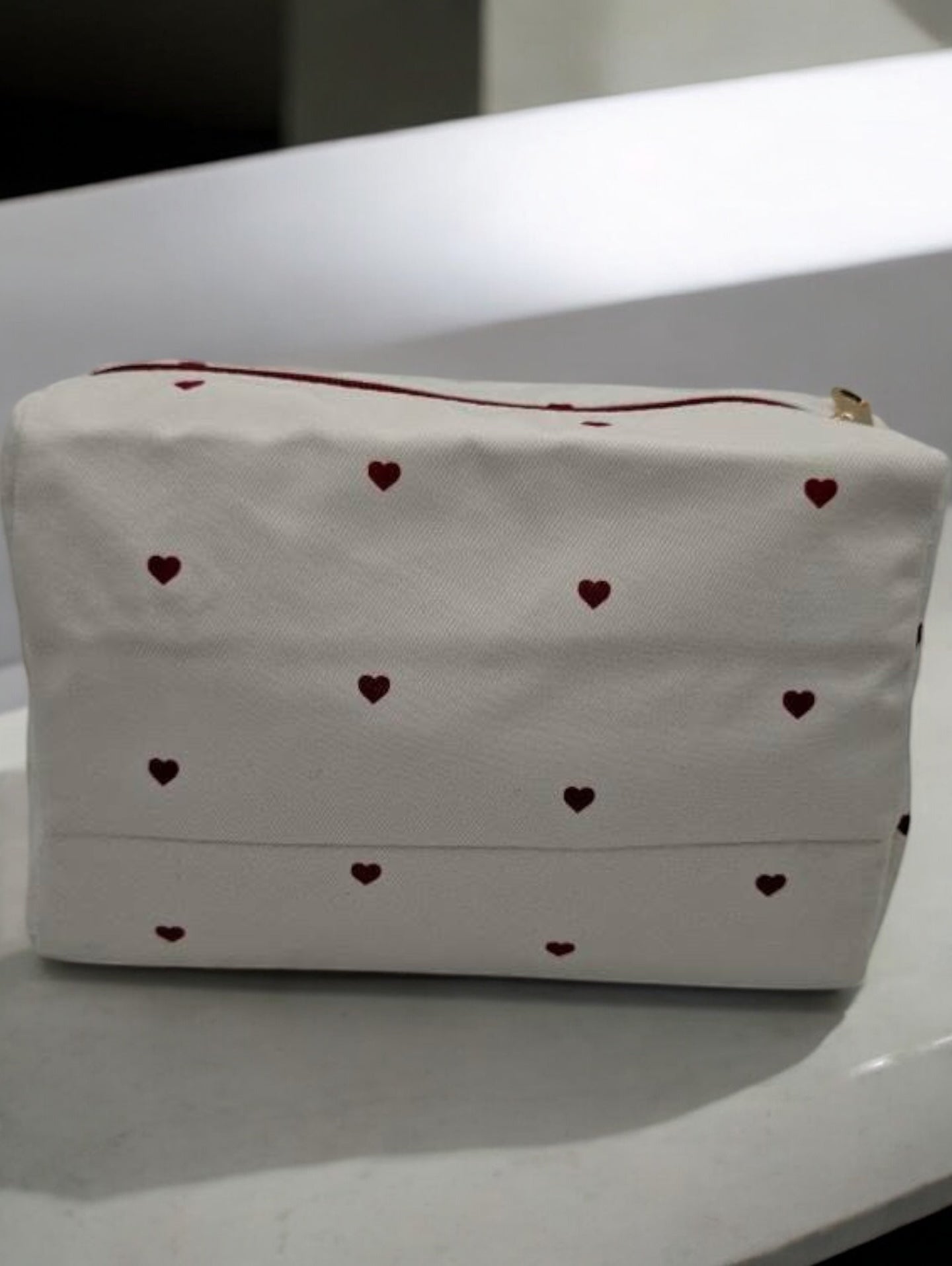 Trousse en tissu imperméable blanc motifs cœurs rouges