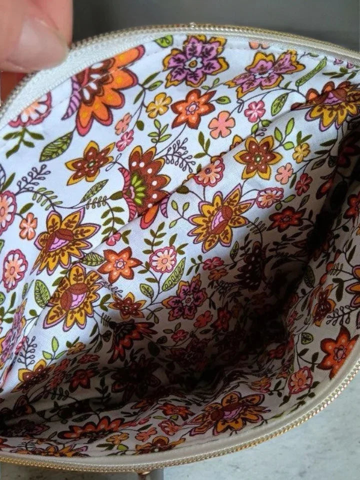 Inside of a zippered pouch with colorful floral fabric lining, trendy accessory at Le Petit Placard