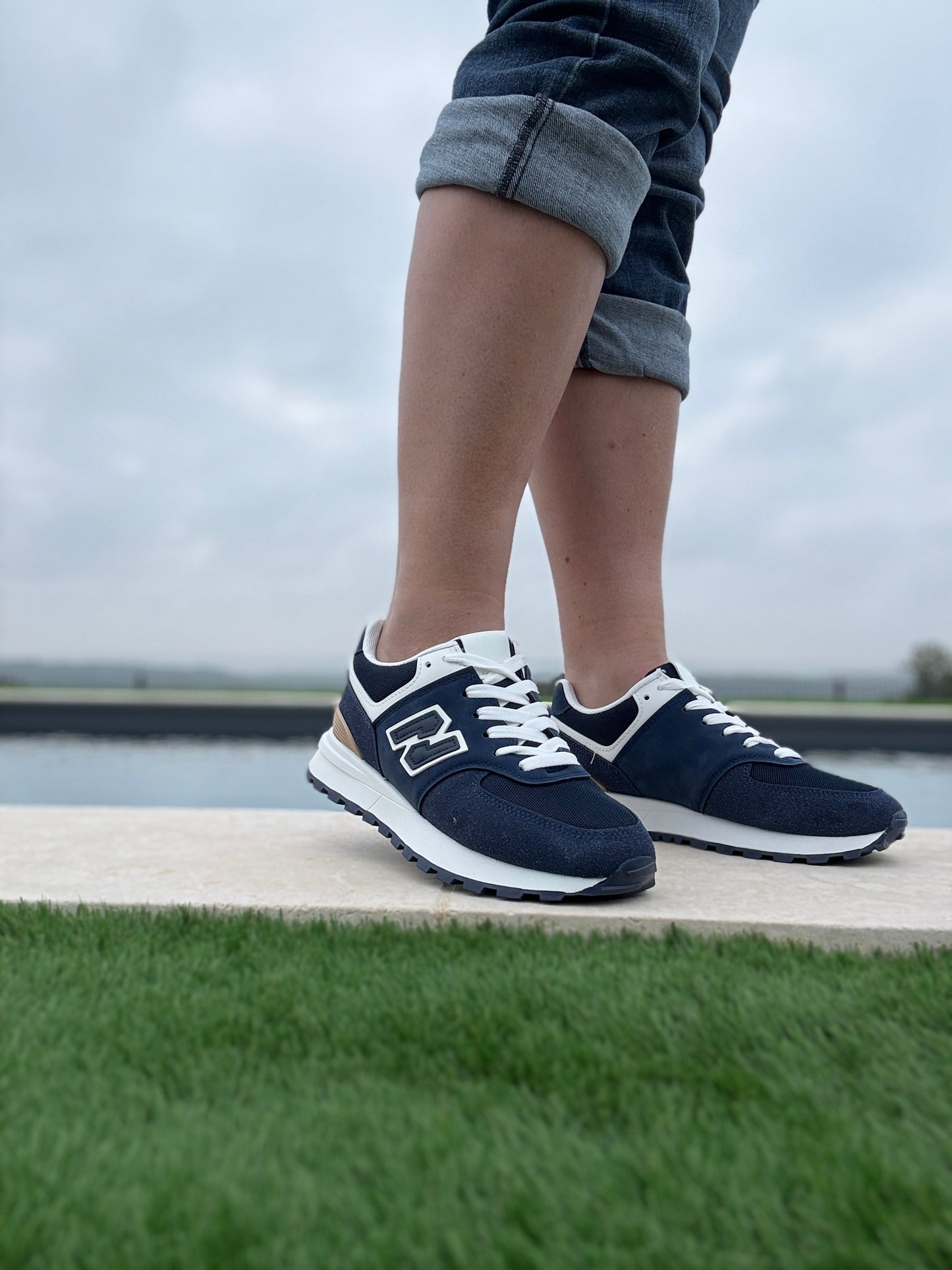 Chaussures baskets bleu marine et blanc avec logo stylisé style sneakers