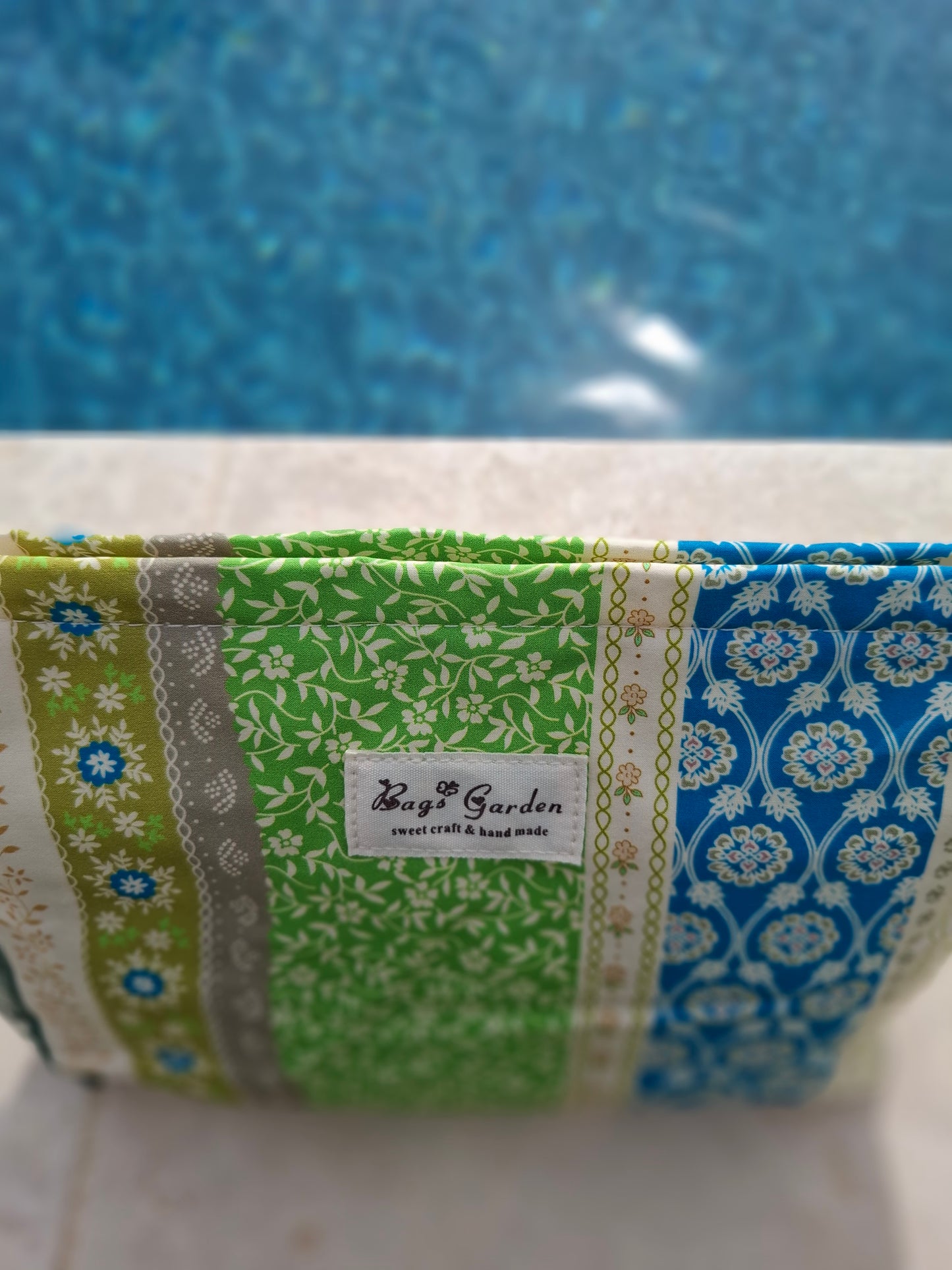 Trousse en tissu imperméabilisé motifs patchwork multicolores imprimés floraux et géométriques vert beige bleu
