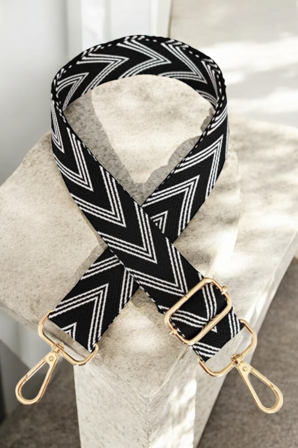 Bandoulière sangle large chevrons noir à motif blanc mousquetons dorés