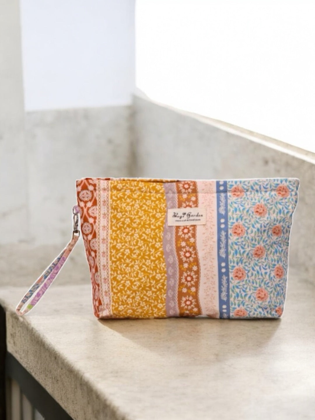 Trousse en tissu imperméabilisé motifs patchwork fleuri avec des motifs géométriques orange rose bleu