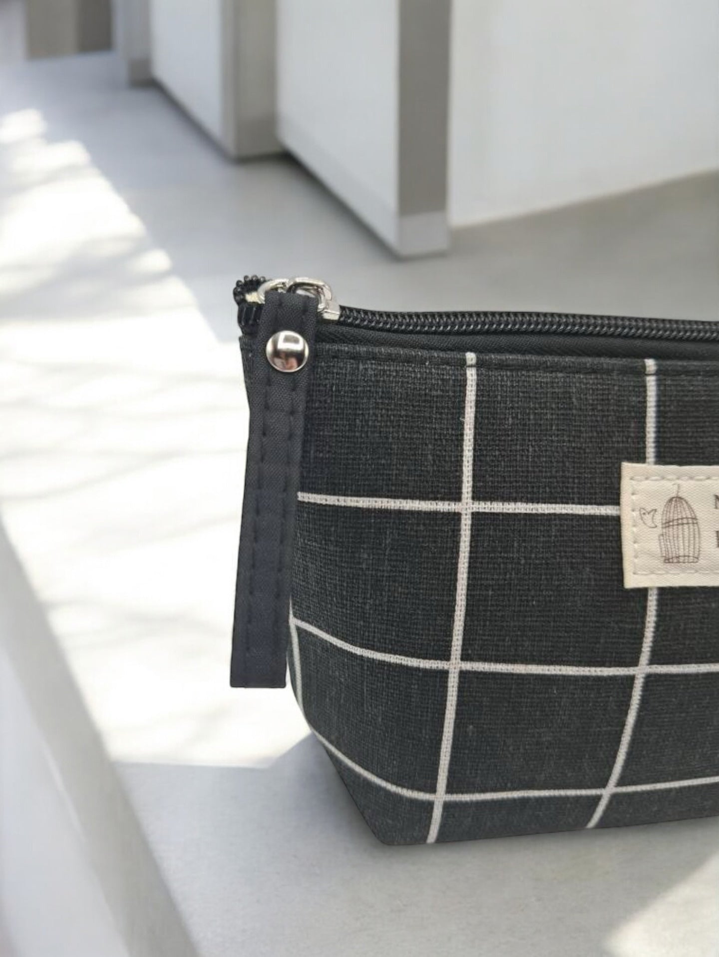 Trousse en coton motif à carreaux blancs sur un fond noir