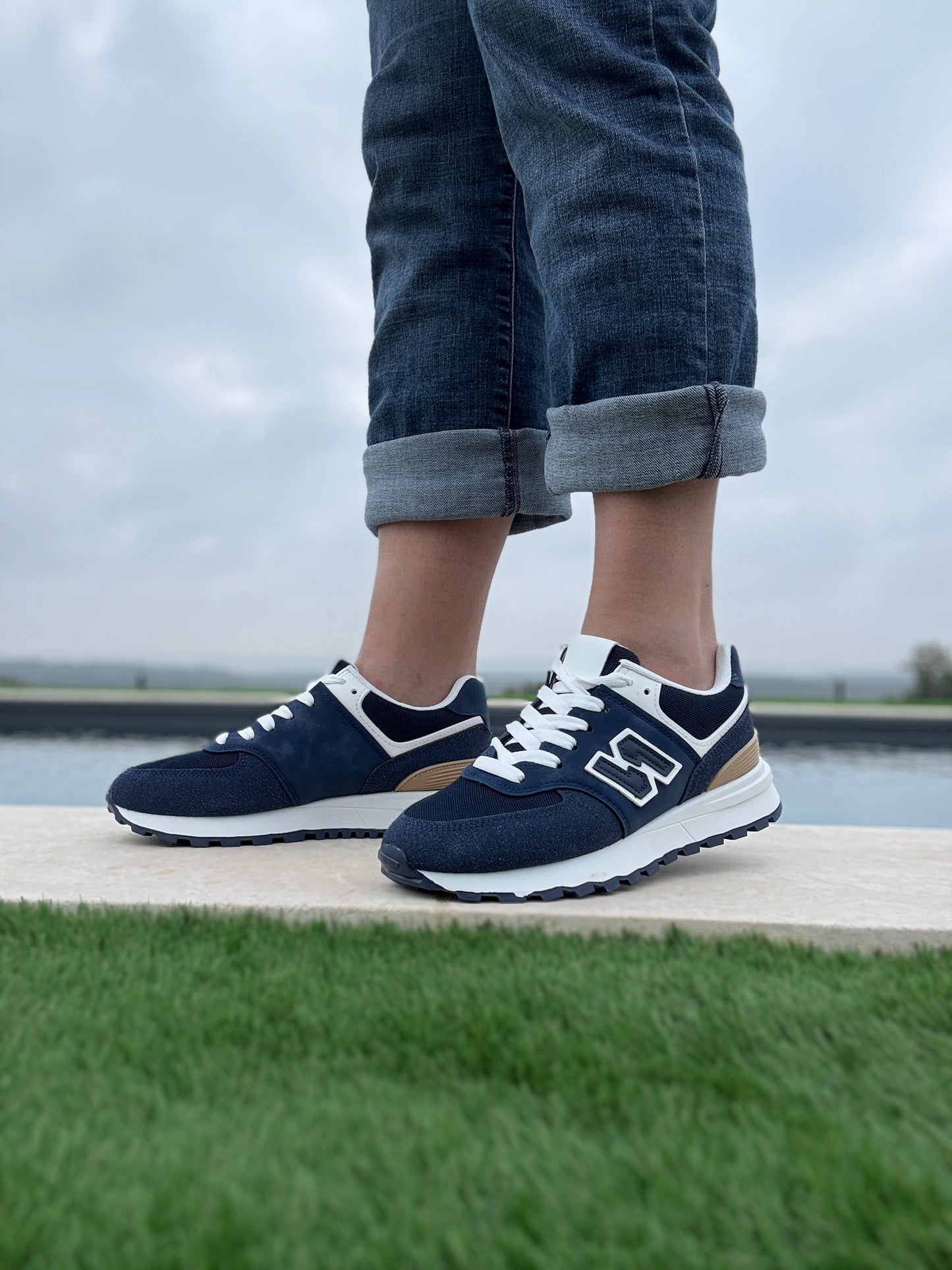 Chaussures baskets bleu marine et blanc avec logo stylisé style sneakers