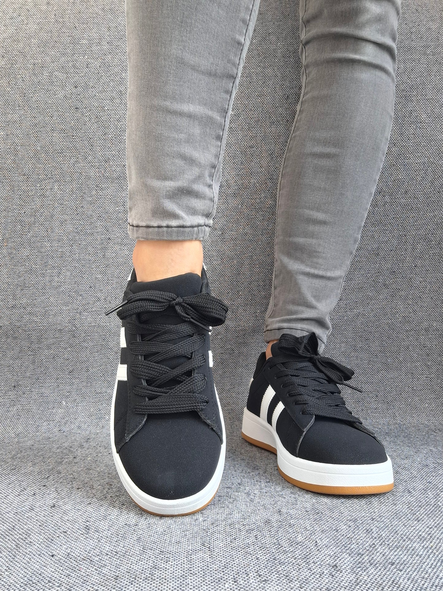 Chaussures baskets basses noir à rayures blanches lacets noirs style sneakers campus