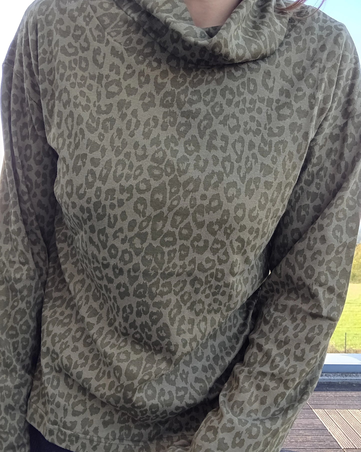 Pull fin col montant motifs léopard kaki porté par une femme, manches longues