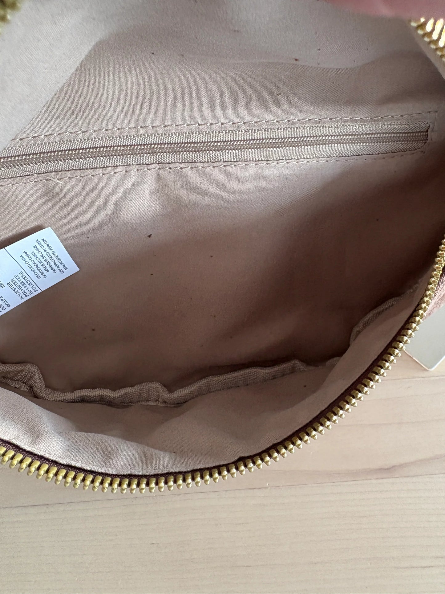 Intérieur du sac banane toucher daim marron chocolat avec poche zippée dorée et doublure beige