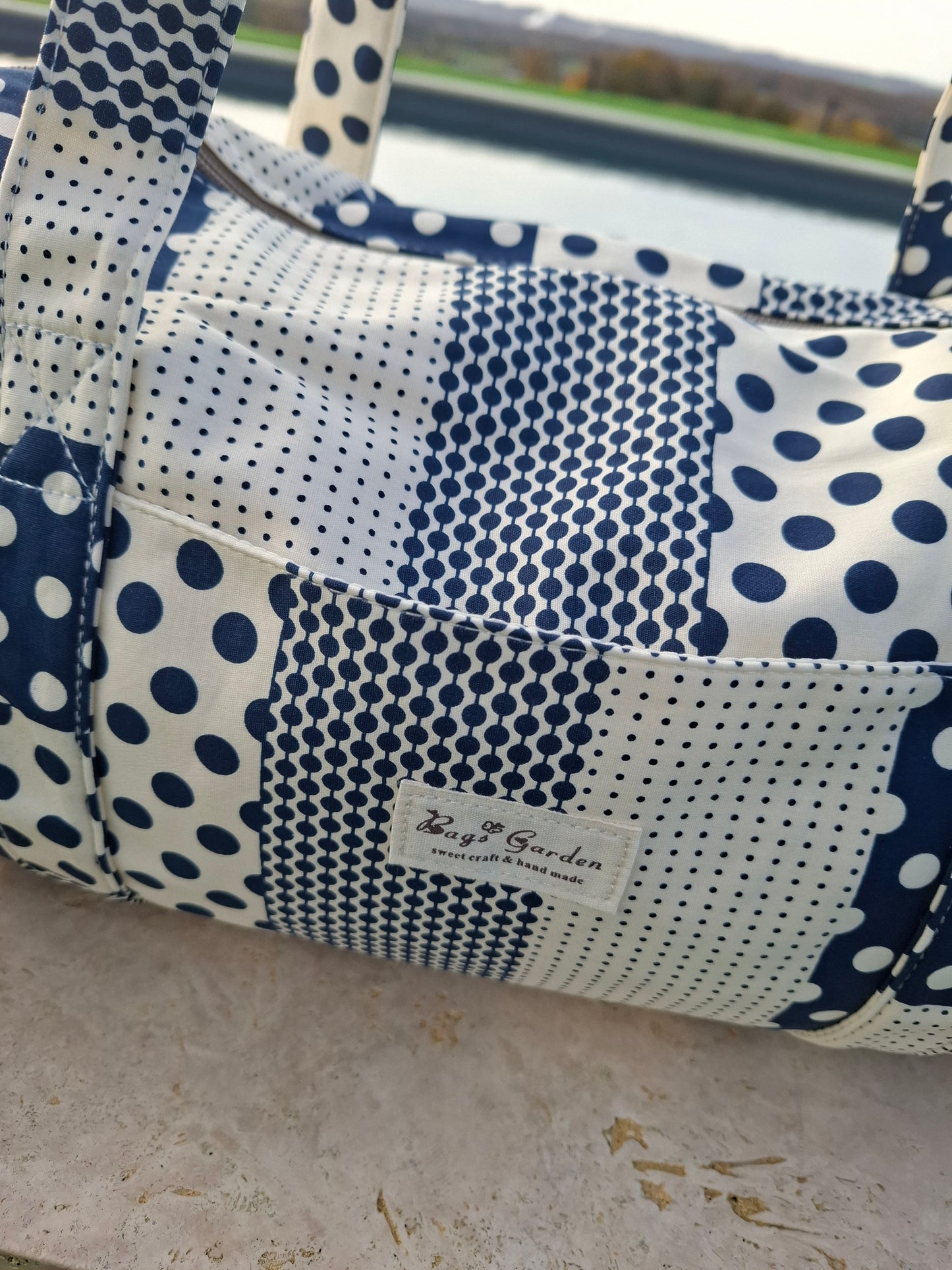 Sac polochon week end de voyage en tissu coton patchwork motifs à pois bleu marine et blanc
