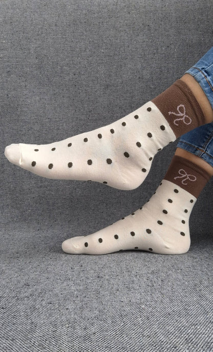 Paire de chaussettes beige en coton à pois noir avec bordure marron et motif nœud blanc