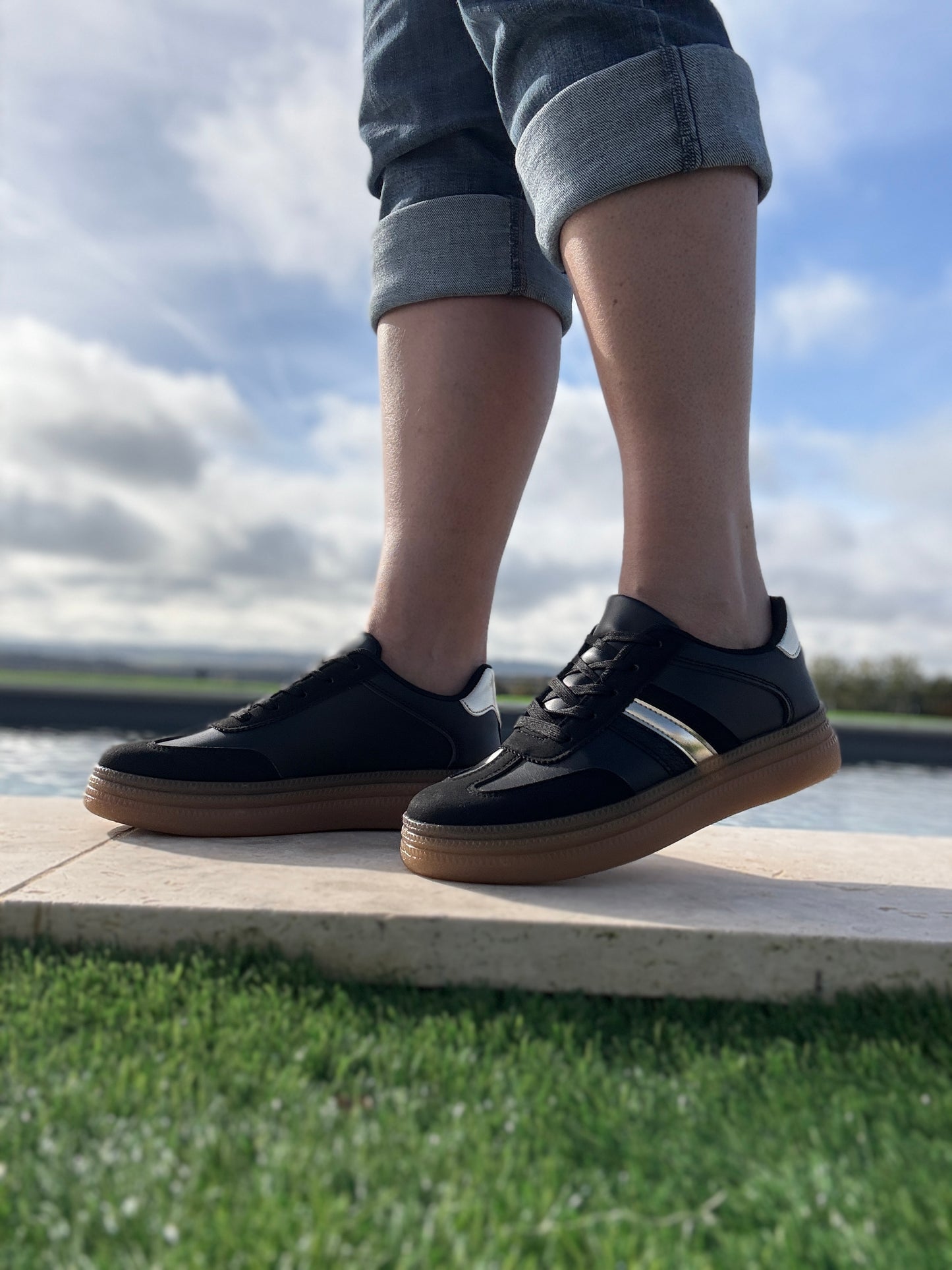 Chaussures baskets basses style sneakers campus noir avec une bande dorée