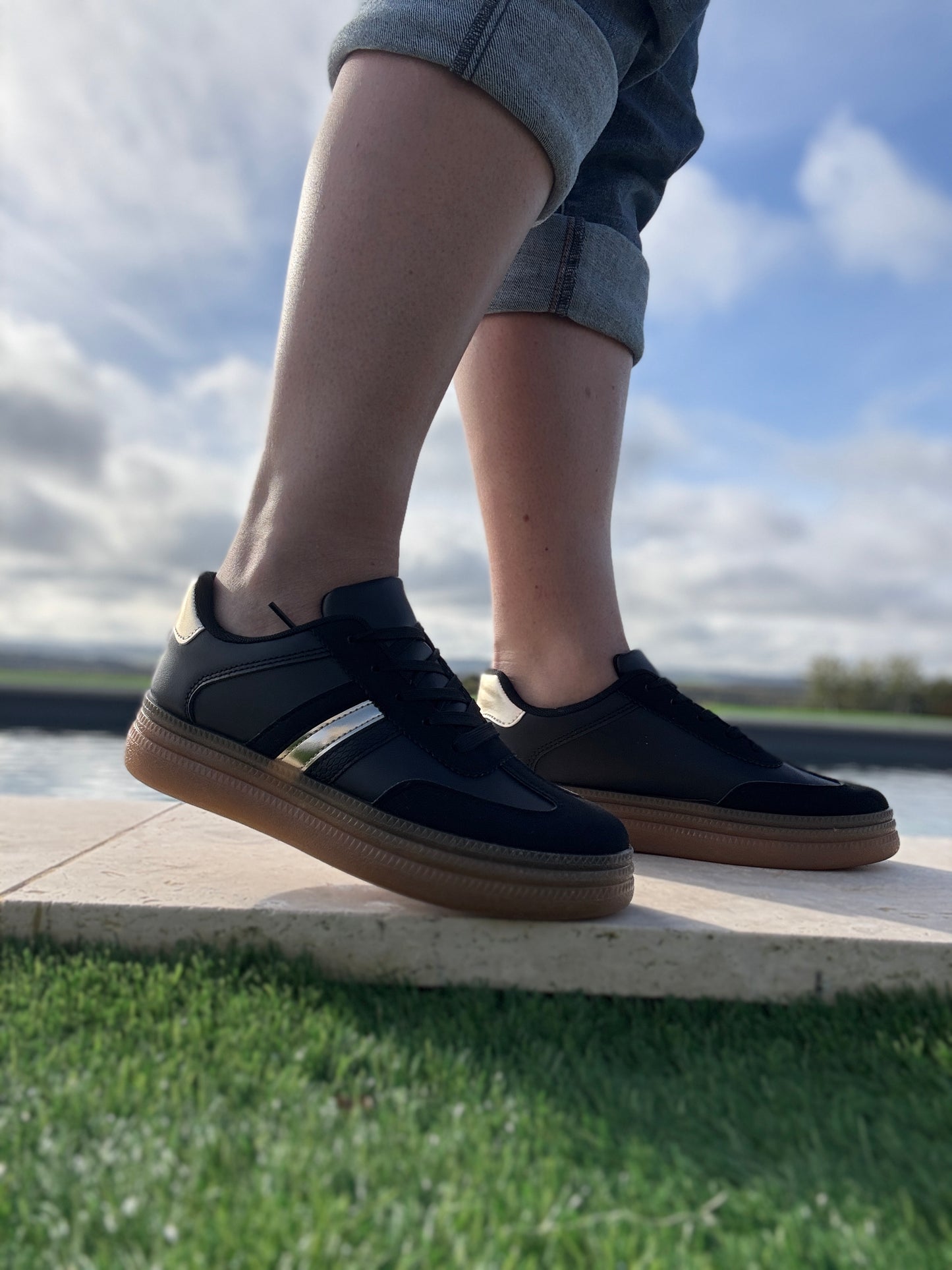 Chaussures baskets basses style sneakers campus noir avec une bande dorée