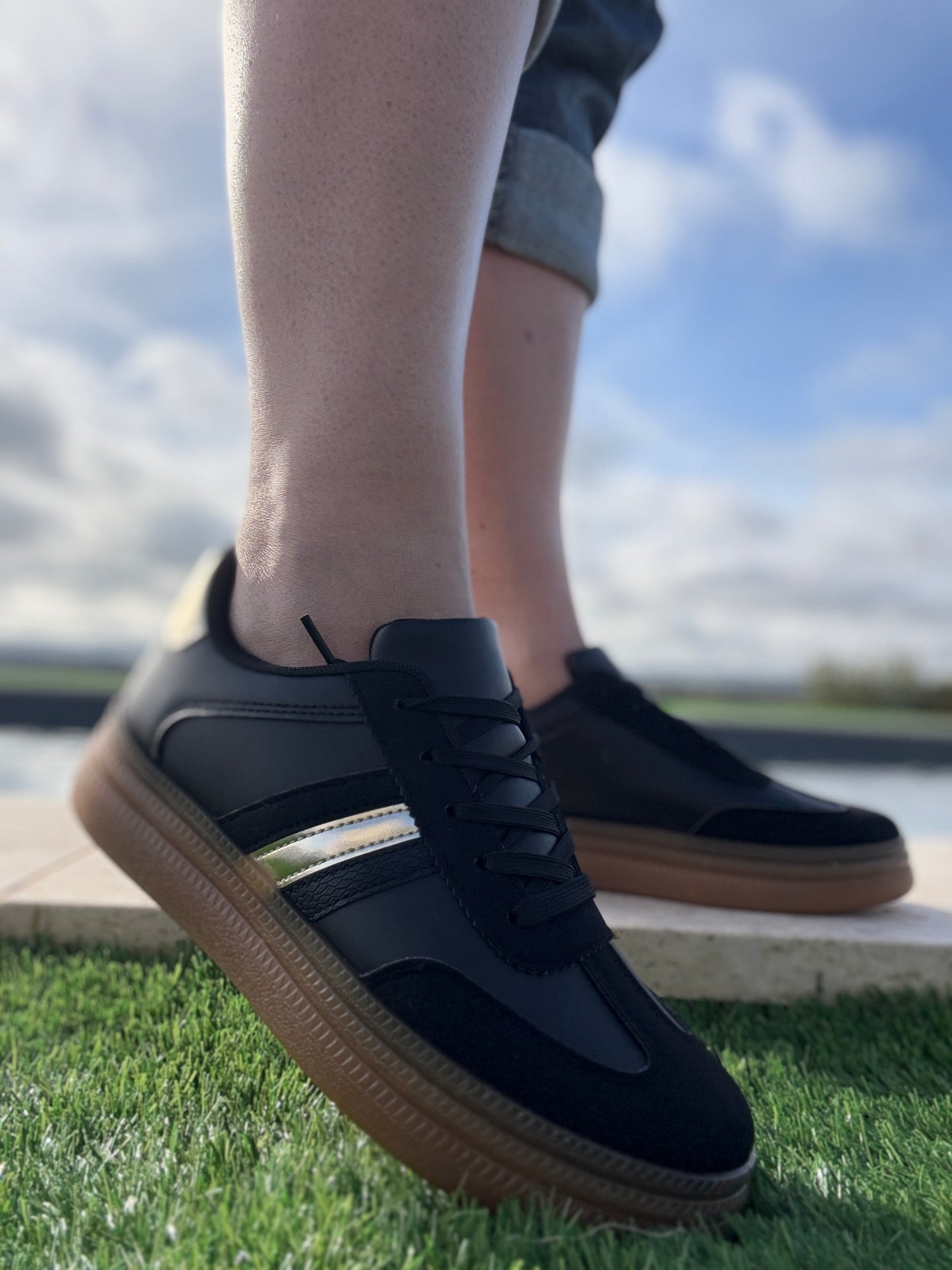 Chaussures baskets basses style sneakers campus noir avec une bande dorée