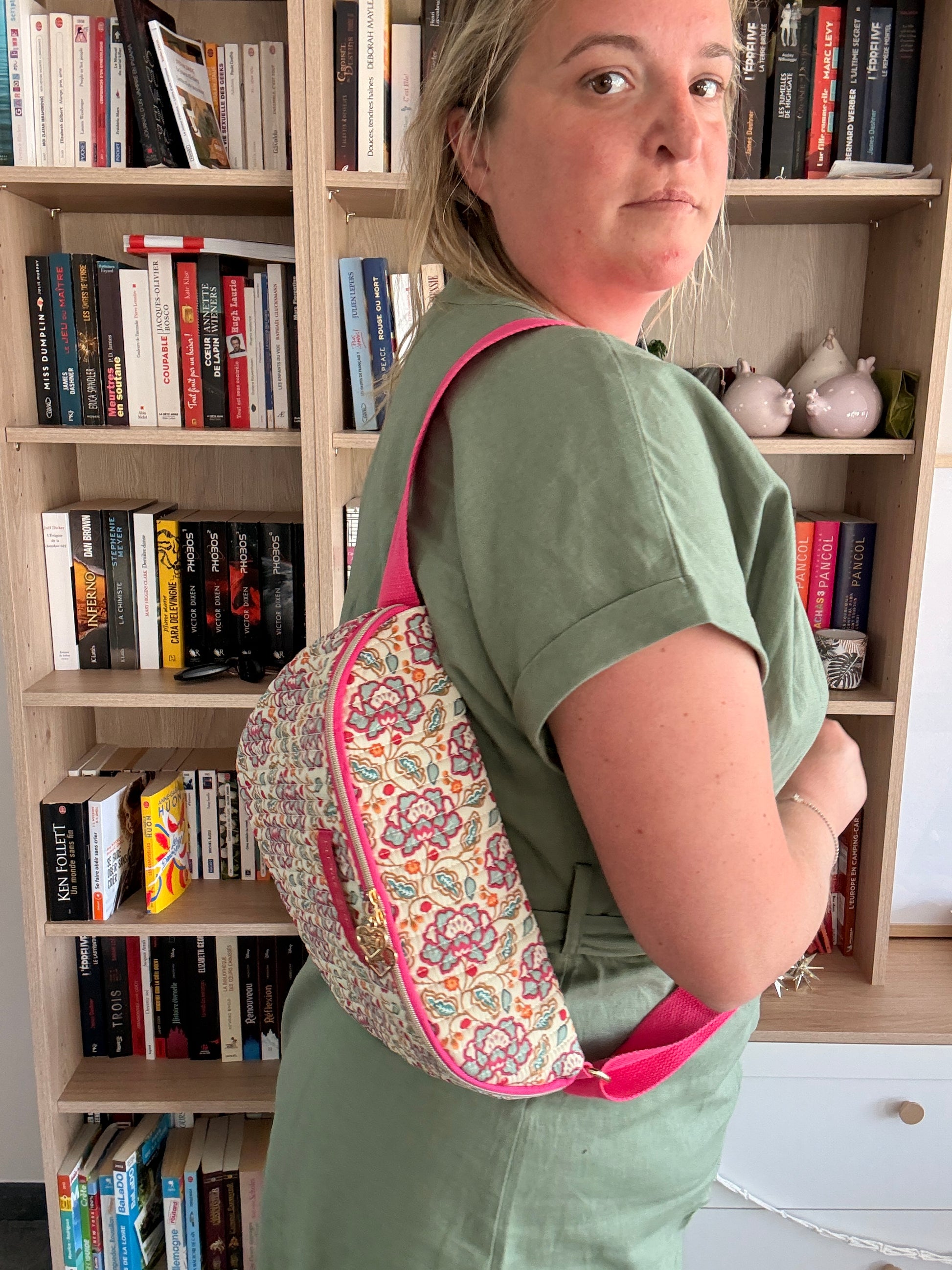 Sac banane Liberty fleuri rose porté en bandoulière par une femme, avec coton beige et finitions dorées visibles sur le modèle.