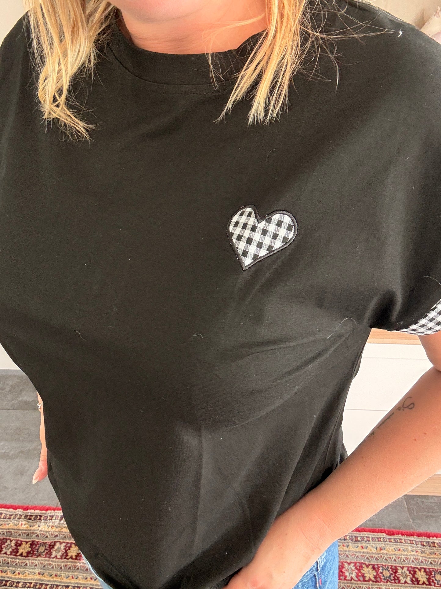T-shirt femme noir oversize avec petit cœur en vichy noir et blanc sur la poitrine, détails vichy sur les manches.