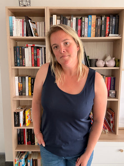Débardeur Femme Bleu Marine – Uni & Confortable porté par une femme devant une bibliothèque.