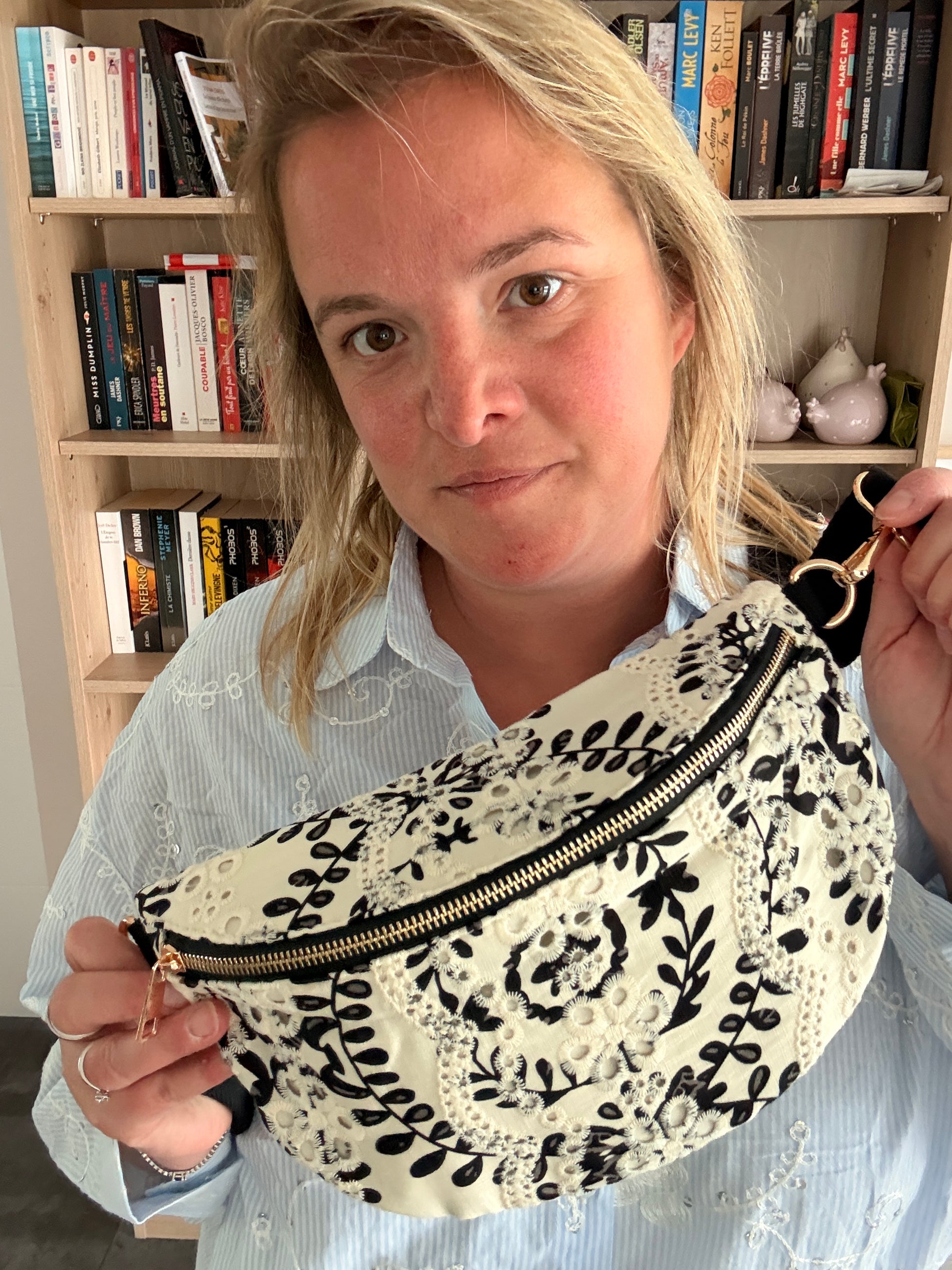 Sac banane femme floral noir et blanc léger et pratique, portée à l’épaule avec une fermeture éclair dorée et motif végétal.