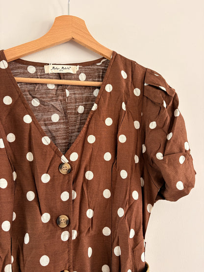 Robe midi à pois beige et marron, manches bouffantes, col en V et ceinture assortie, style vintage sur cintre.