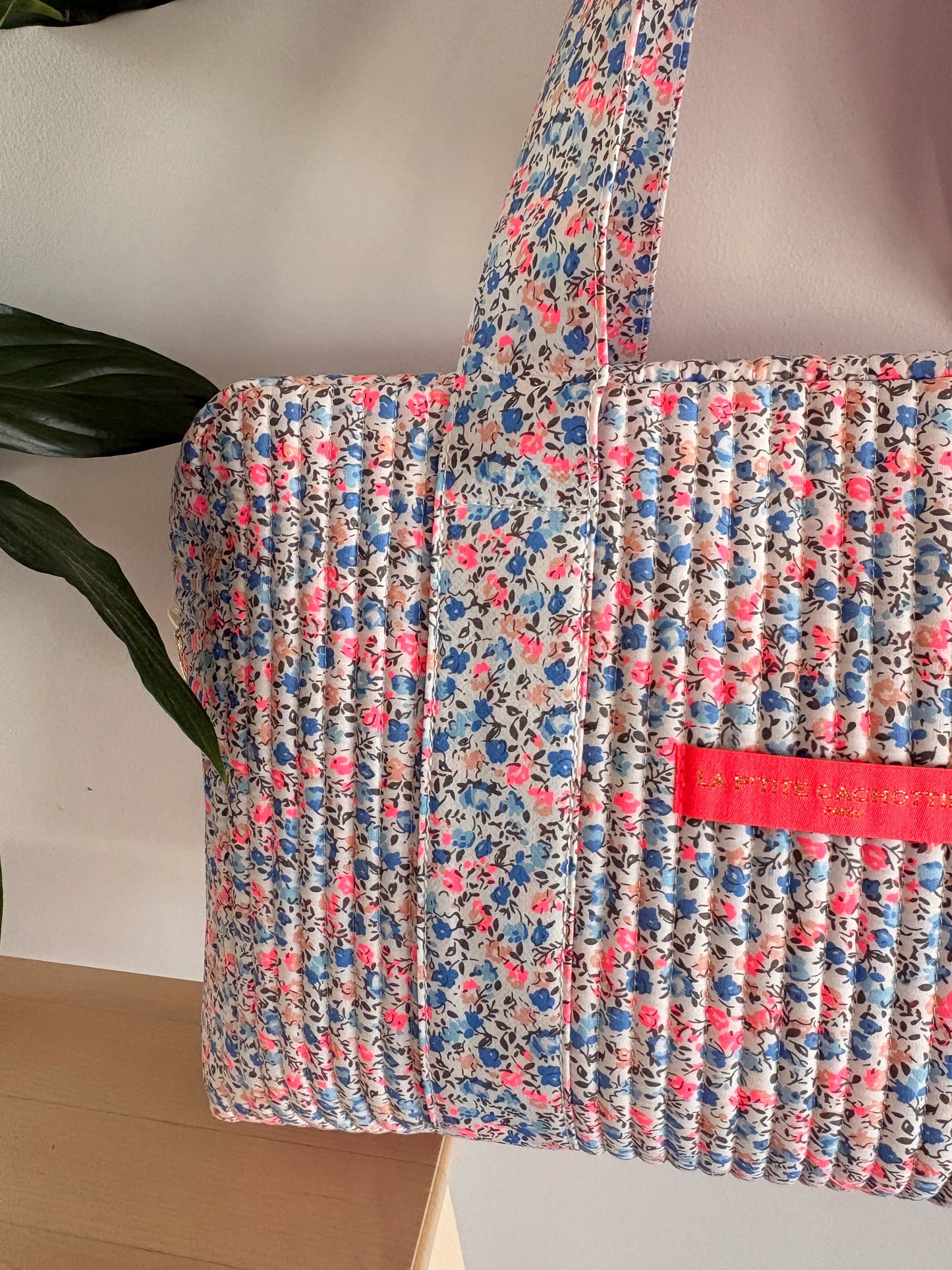 Sac polochon matelassé imprimé liberty lilas, rose et bleu avec poignée, détail poche rose vif.