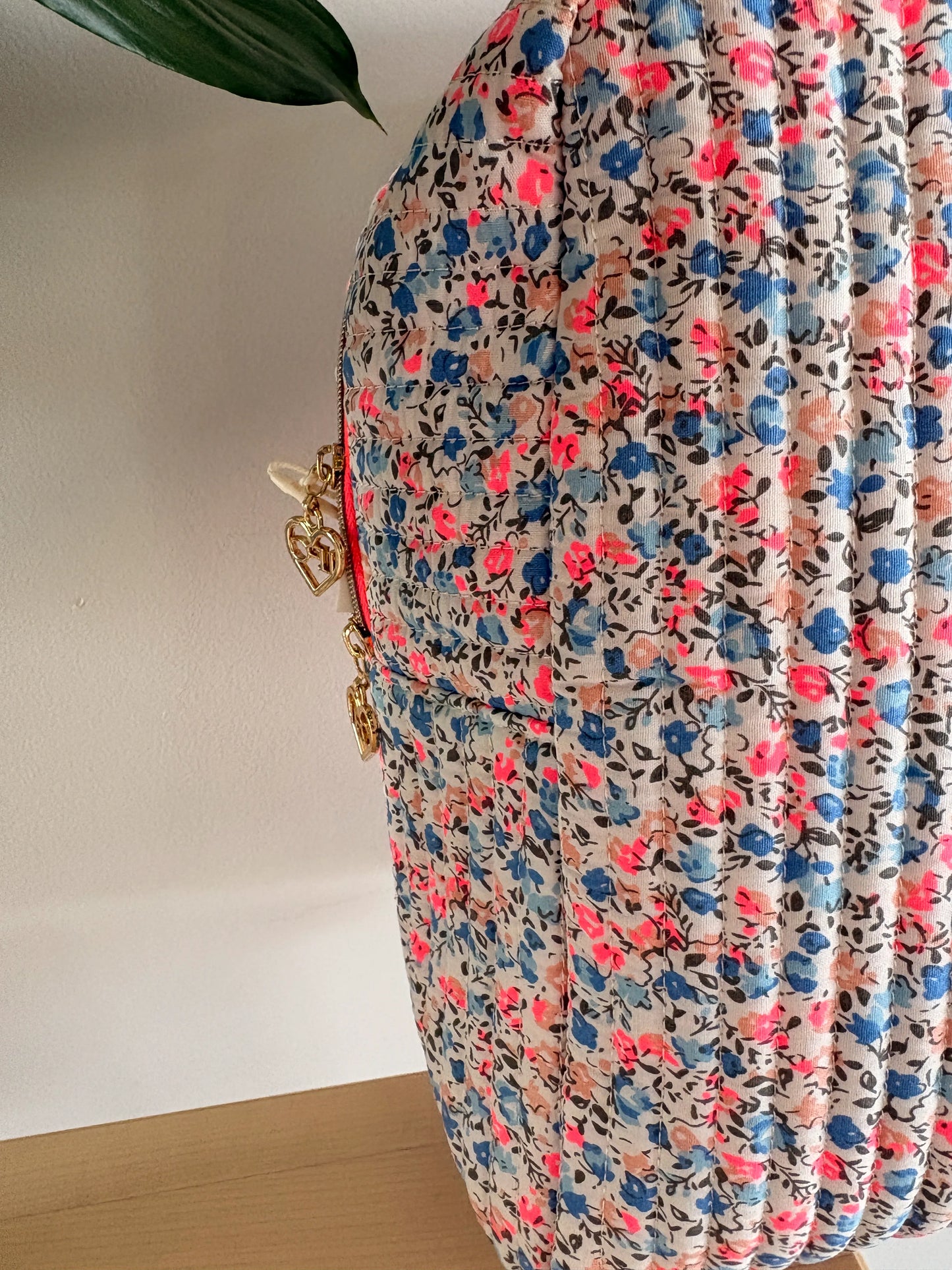 Sac polochon matelassé floral imprimé Liberty lilas, rose et bleu avec zipper doré et détails chaînes.