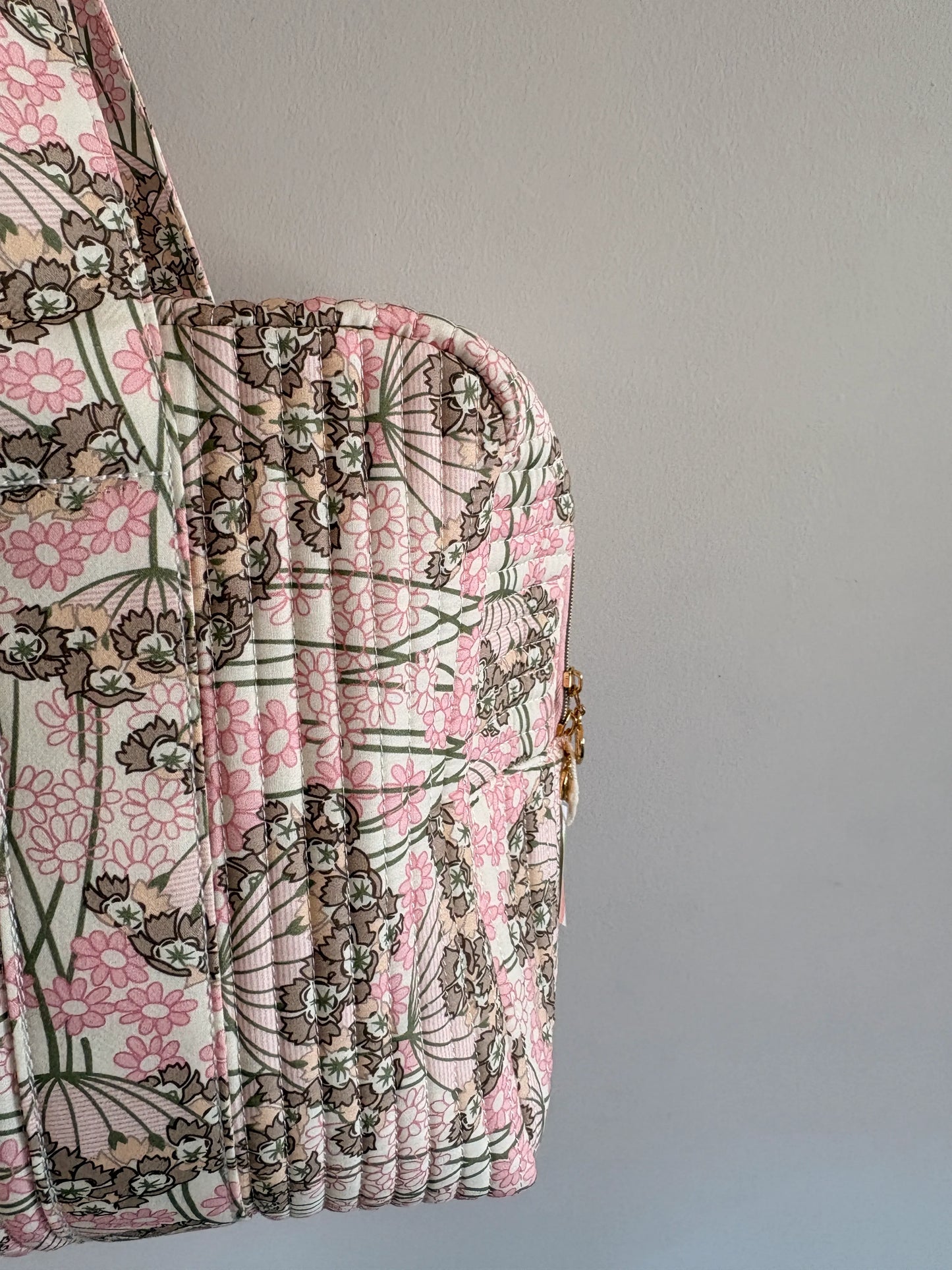 Sac polochon matelassé rose fleuri pour bagage cabine et voyage femme, vue latérale sur le motif floral.