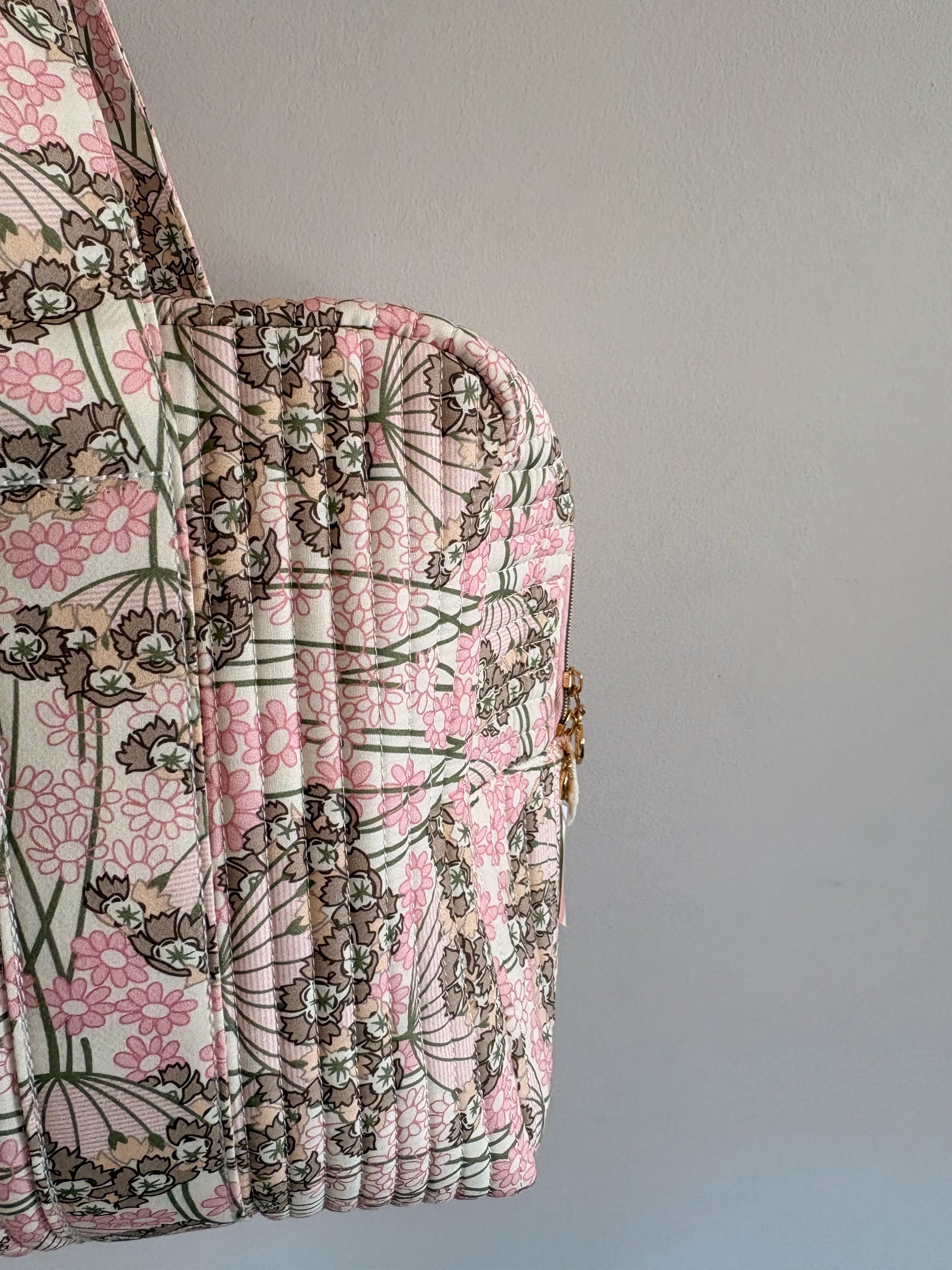 Sac polochon matelassé rose fleuri pour bagage cabine et voyage femme, vue latérale sur le motif floral.