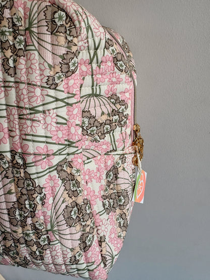 Sac polochon matelassé rose fleuri avec motif floral, cadenas doré et étiquette, prêt pour voyage cabine.