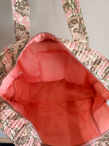 Sac polochon matelassé rose fleuri, intérieur rose uniforme bien spacieux avec poche latérale et poches sashawo. Idéal bagage cabine femme.