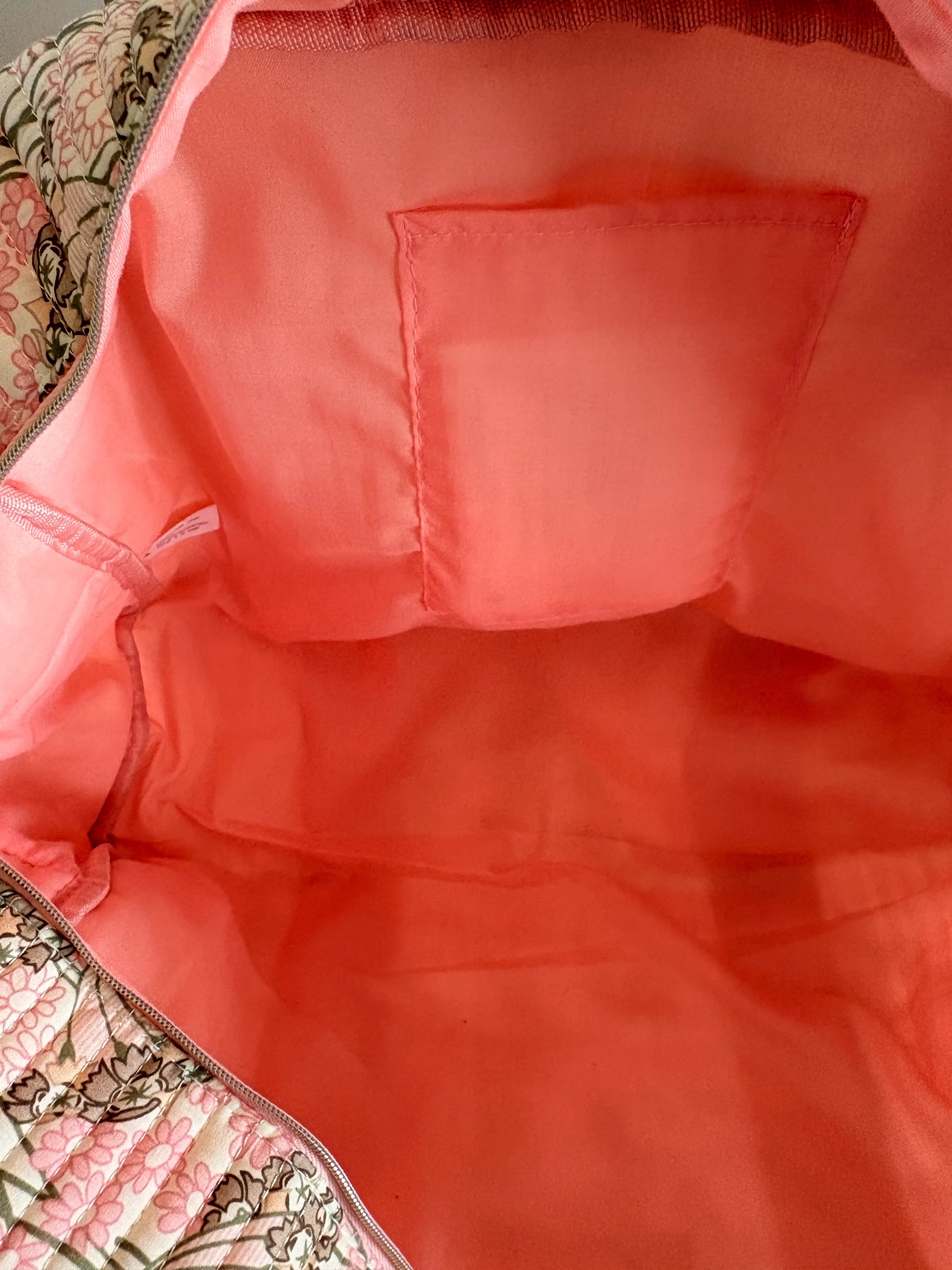 Sac polochon matelassé rose floral, intérieur rose vif avec poche plaquée à l’arrière. Parfait pour bagage cabine et voyage femme.