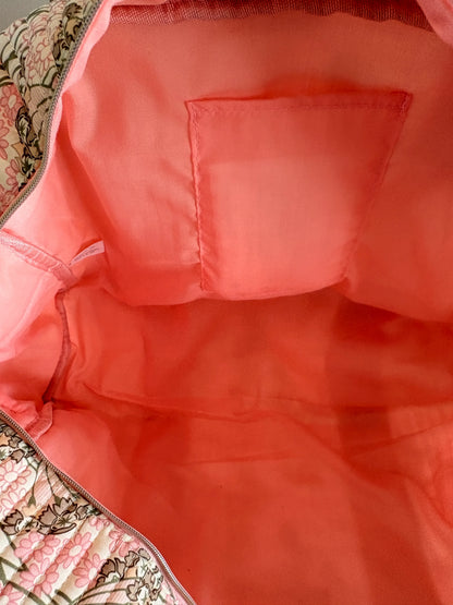 Sac polochon matelassé rose floral, intérieur rose vif avec poche plaquée à l’arrière. Parfait pour bagage cabine et voyage femme.