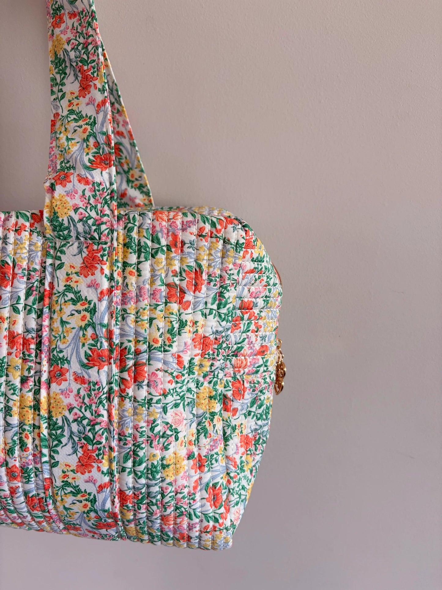 Sac polochon matelassé fleuri vert menthe avec imprimé fleurs, forme cabas élégant et léger.