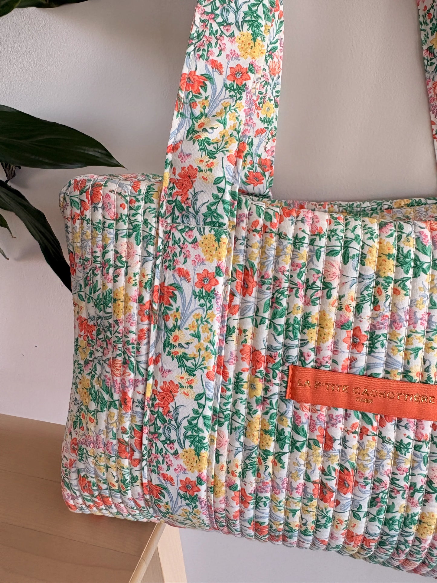 Sac polochon matelassé fleuri vert menthe imprimé fleurs femme, vue proche d’un sac à dos/pochettes à fleurs pastel.