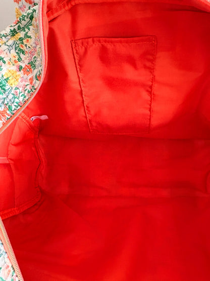 Sac polochon matelassé vert menthe à imprimé fleurs femme, intérieur rouge vif avec pochette plaquée et zippée.