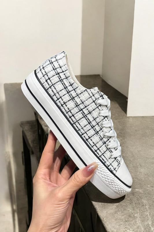 Chaussures baskets basses blanches avec un liseré noir style converse