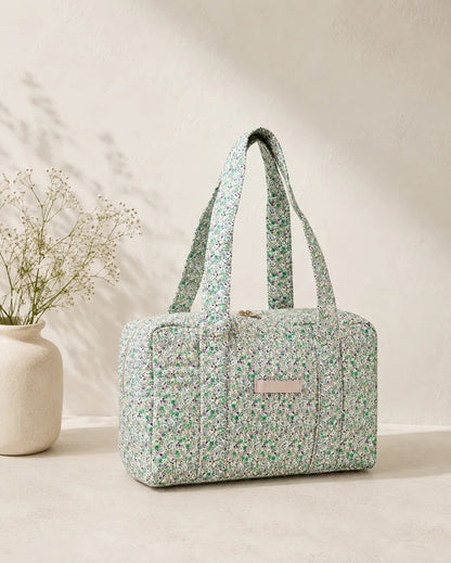 Sac polochon vert à motif floral, grande poche zippée et anses matelassées, parfait pour voyage femme.