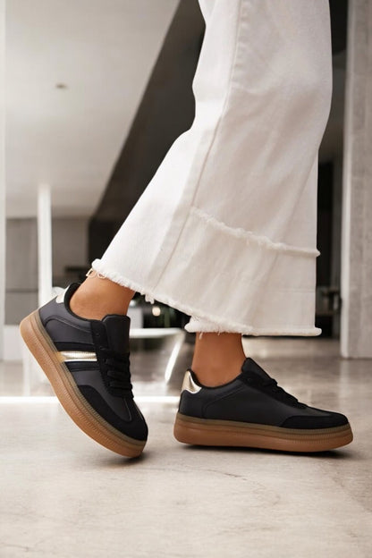 Chaussures baskets basses style sneakers campus noir avec une bande dorée