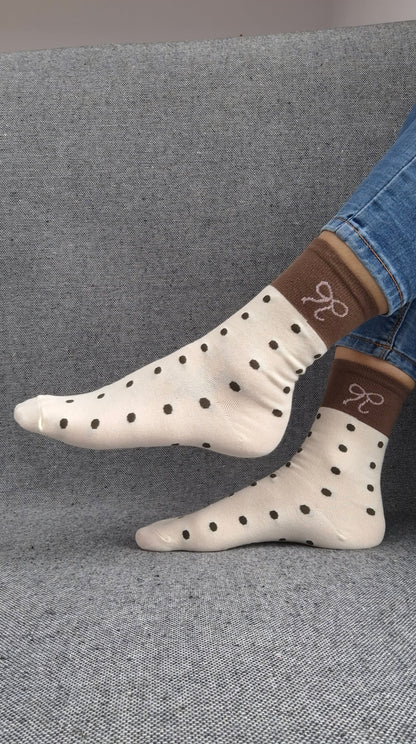 Paire de chaussettes beige en coton à pois noir avec bordure marron et motif nœud blanc