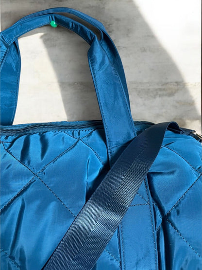 Sac polochon matelassé bleu avec anses et bandoulière réglable