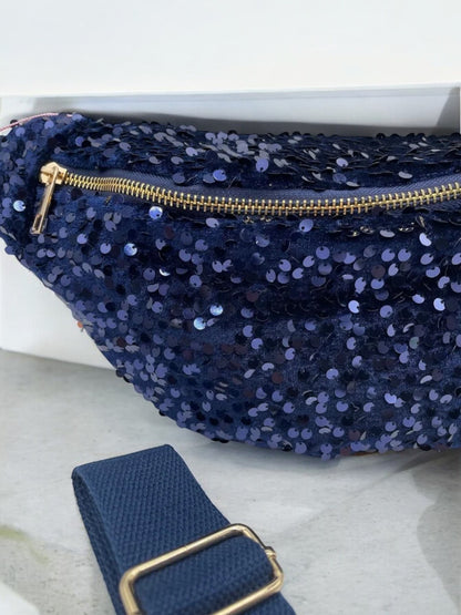 Sac banane bleu marine à paillettes avec fermeture éclair dorée et bandoulière réglable, démonstration du matériel brillants.