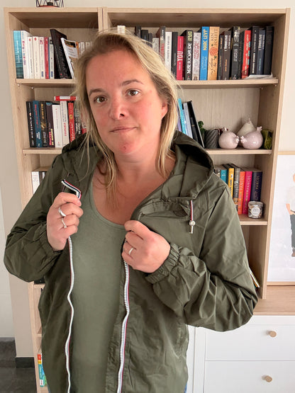Gros plan sur le zip tricolore et la doublure intérieure du coupe-vent kaki Laura Jo, veste ouverte tenue à deux mains