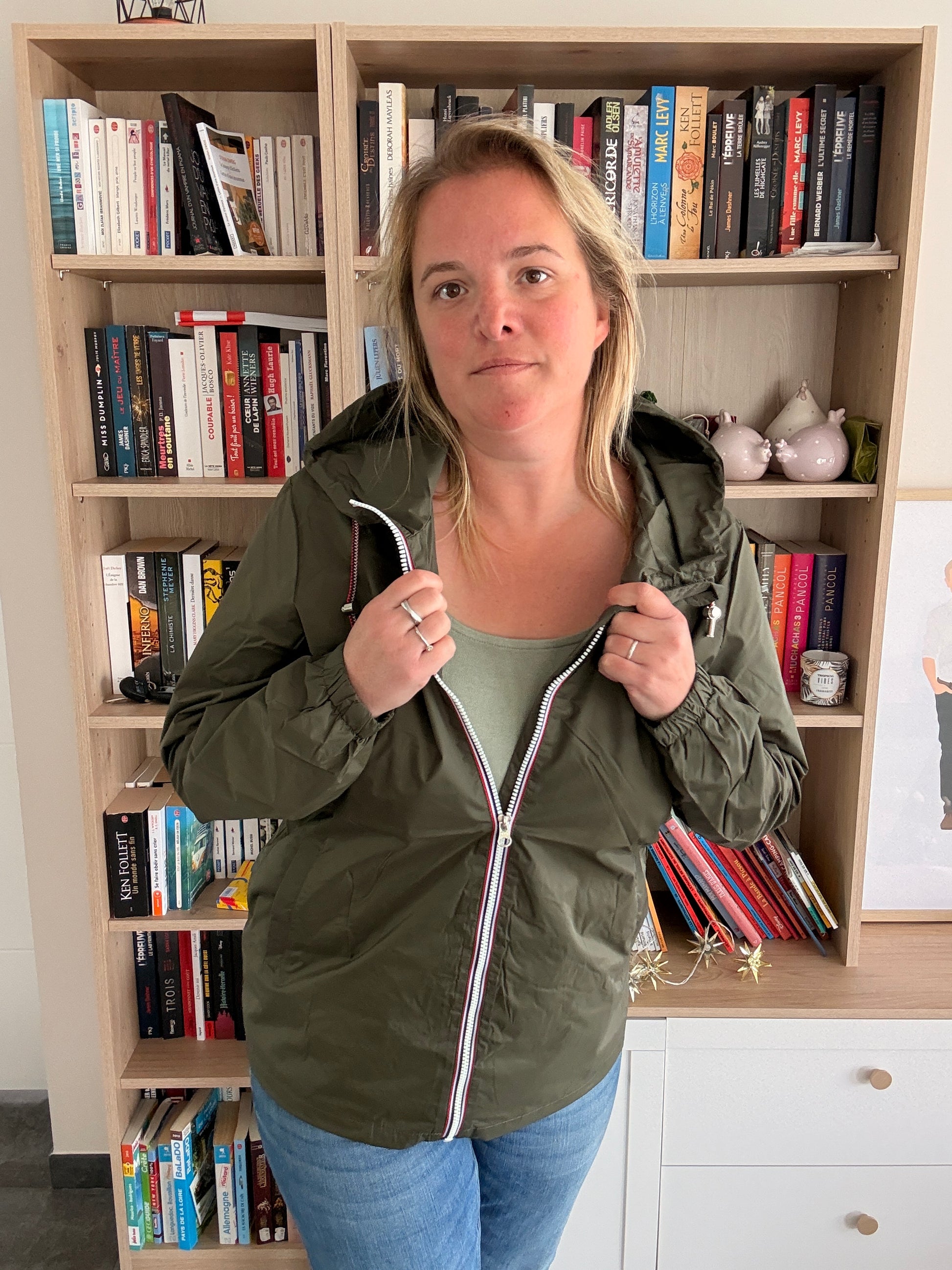 Femme portant le coupe-vent imperméable kaki Laura Jo ouvert, zip tricolore visible, top kaki en dessous