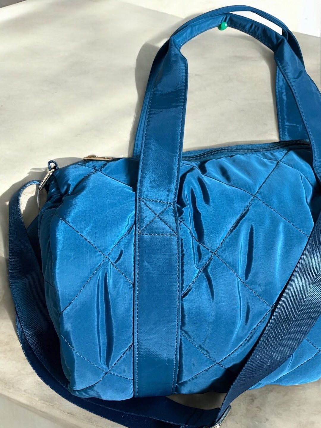 Sac polochon matelassé bleu avec anses et bandoulière réglable