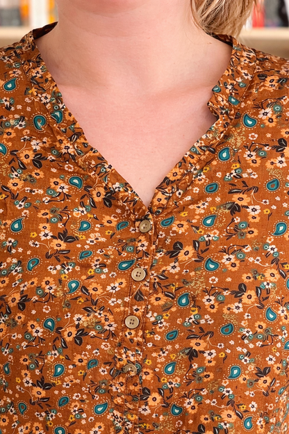 Blouse florale caramel Le Petit Placard avec col V volant, détails de fleurs et tissu léger visible sur l'image.