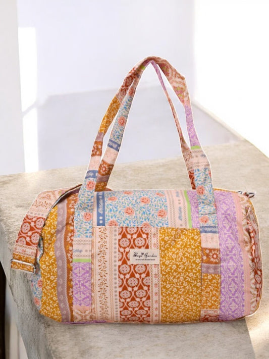 Sac polochon en tissu motifs patchwork fleurs avec des motifs géométriques en orange, rose, bleu