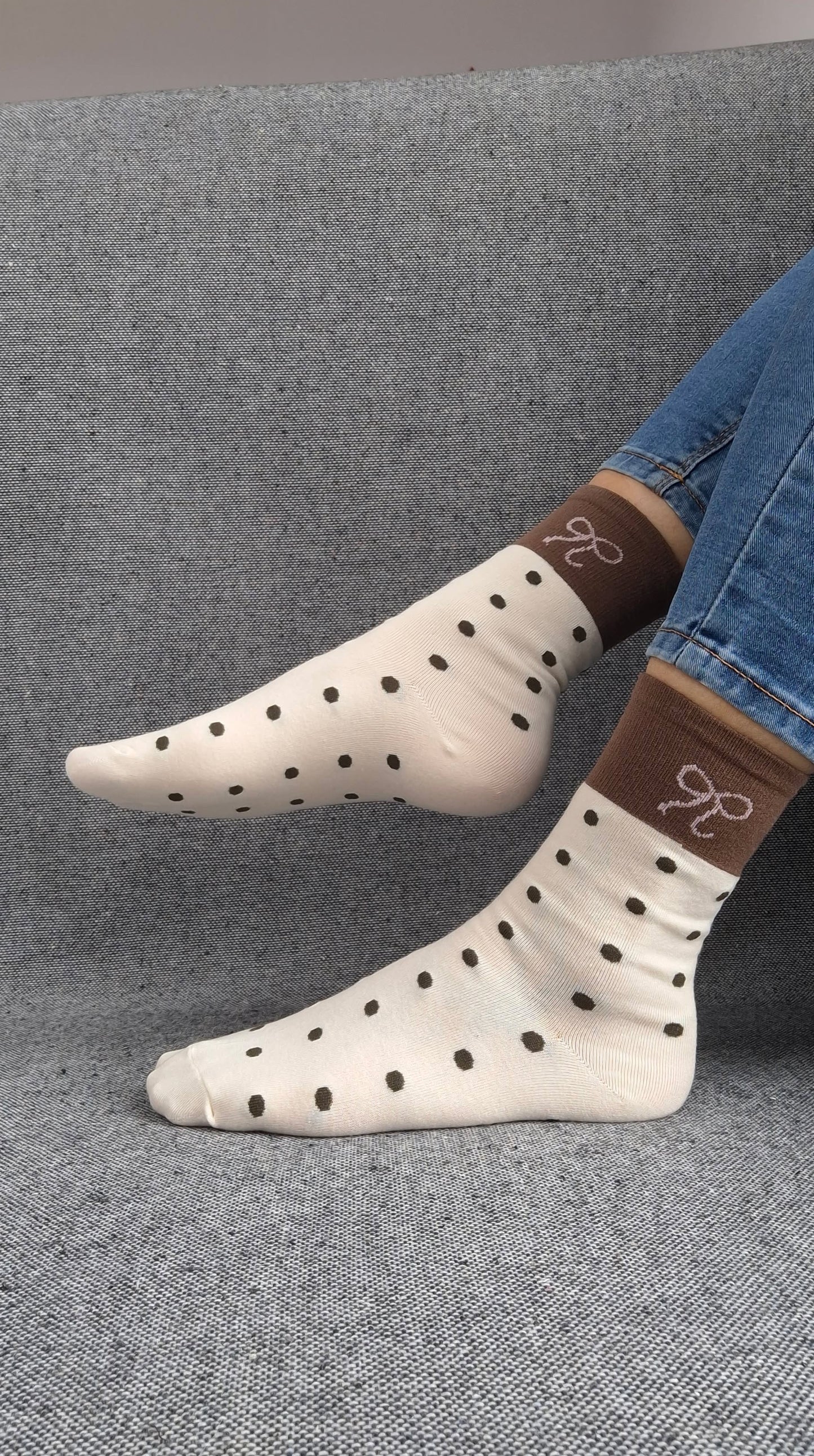 Paire de chaussettes beige en coton à pois noir avec bordure marron et motif nœud blanc